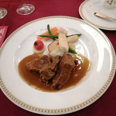 흰 접시 위에 스테이크 3조각과 사과등이 플레이팅 되어 있다