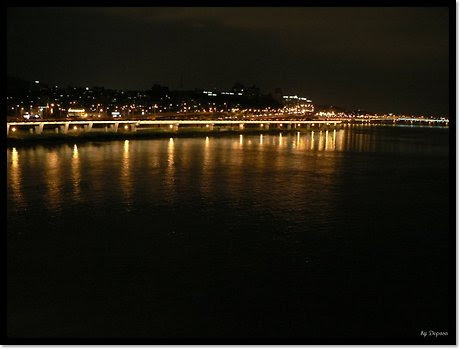 서울 반포대교 중간 지점에서 북동쪽을 향해 촬영한 야경. 강변북로를 따라 이어진 차량 불빛과 도로 조명이 한강 수면 위에 길게 반사되고 있으며, 화면 오른쪽에는 한남대교의 일부가 어둠 속에 실루엣처럼 나타난다. 도심의 불빛과 흐르는 교통이 어우러져 서울의 활기찬 밤 풍경을 담아낸다.