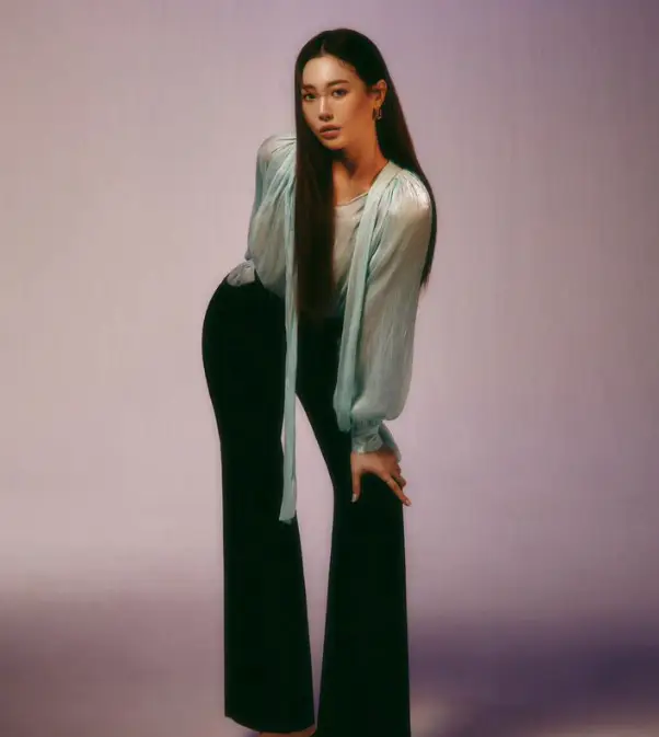 환승연애3- 보라색 배경 파란 망사블라우스에 검은색 긴바지를 입고 포즈를 취하는 유라