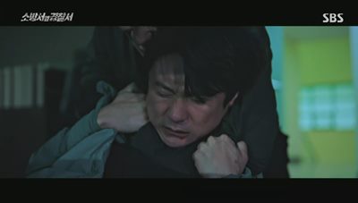 범인에게 목이 졸려 기절하는 형사