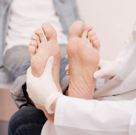 환자의 발 통증을 체크하는 의사