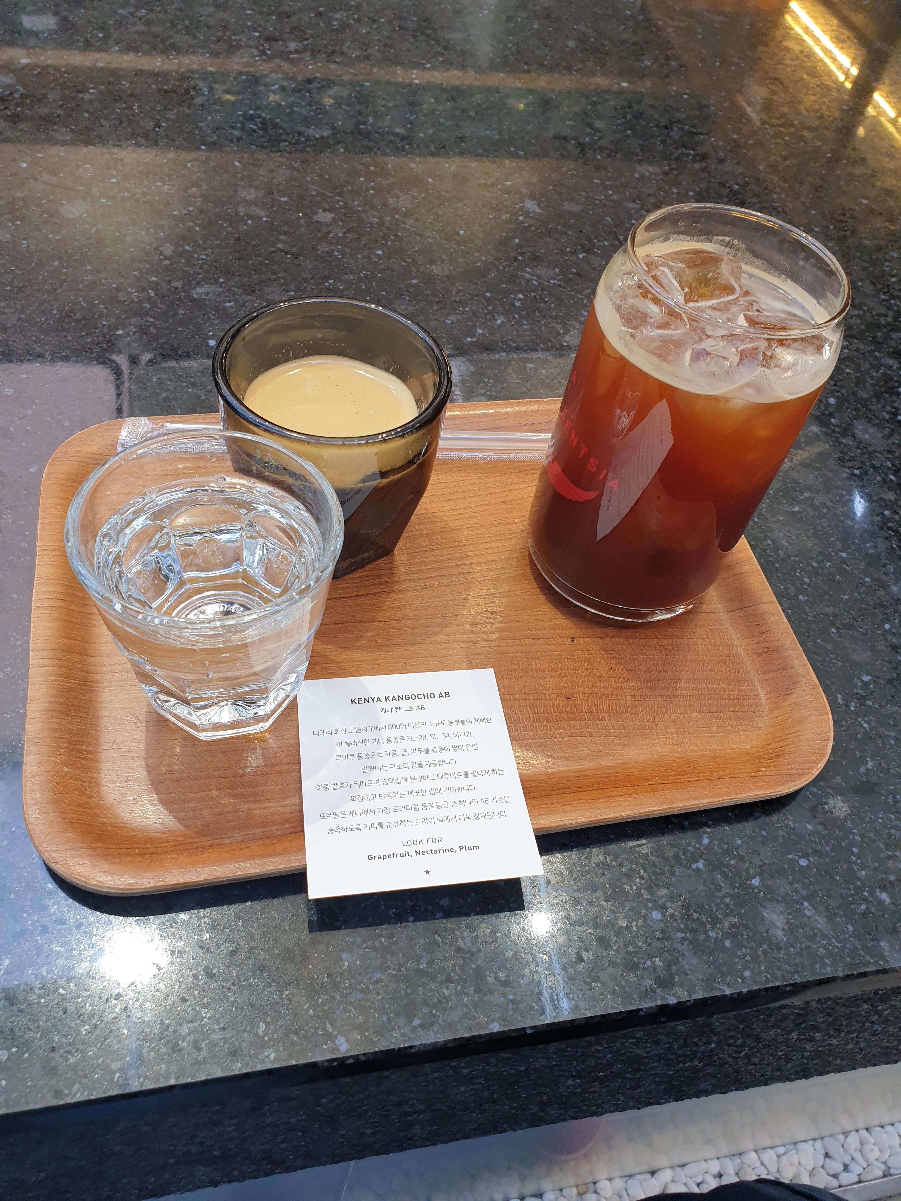 탄산수 에스프레소 아메리카노가 놓인 쟁반이 테이블위에 놓여 있다. 왼쪽부터 탄산수,에스프레소, 아메리카노