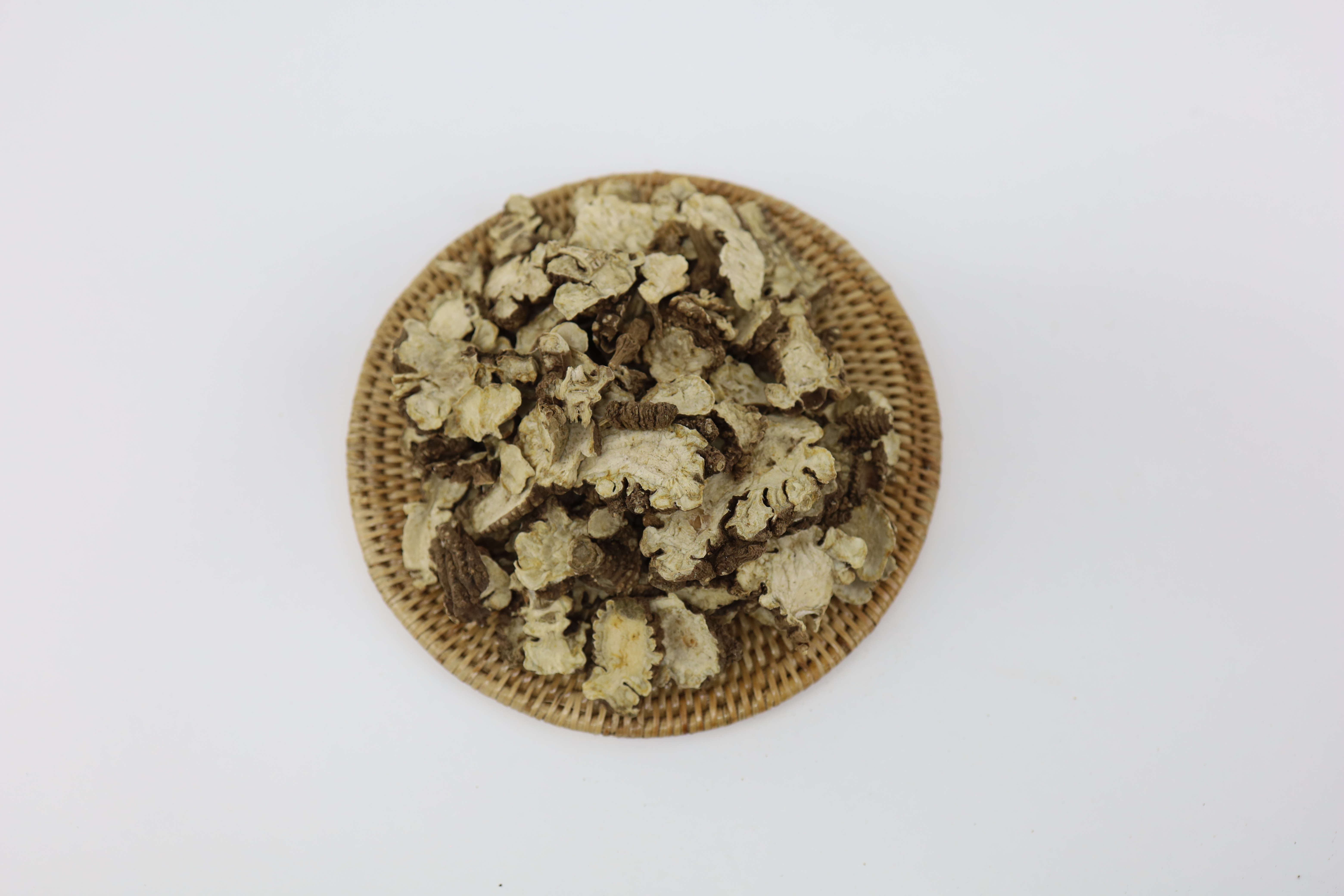 야생에서 채취를 한 천궁을 잘 세척해서 편으로 자른 후에 대나무로 만든 동그란 깔판 위에 수북하게 쌓아 놓은 사진