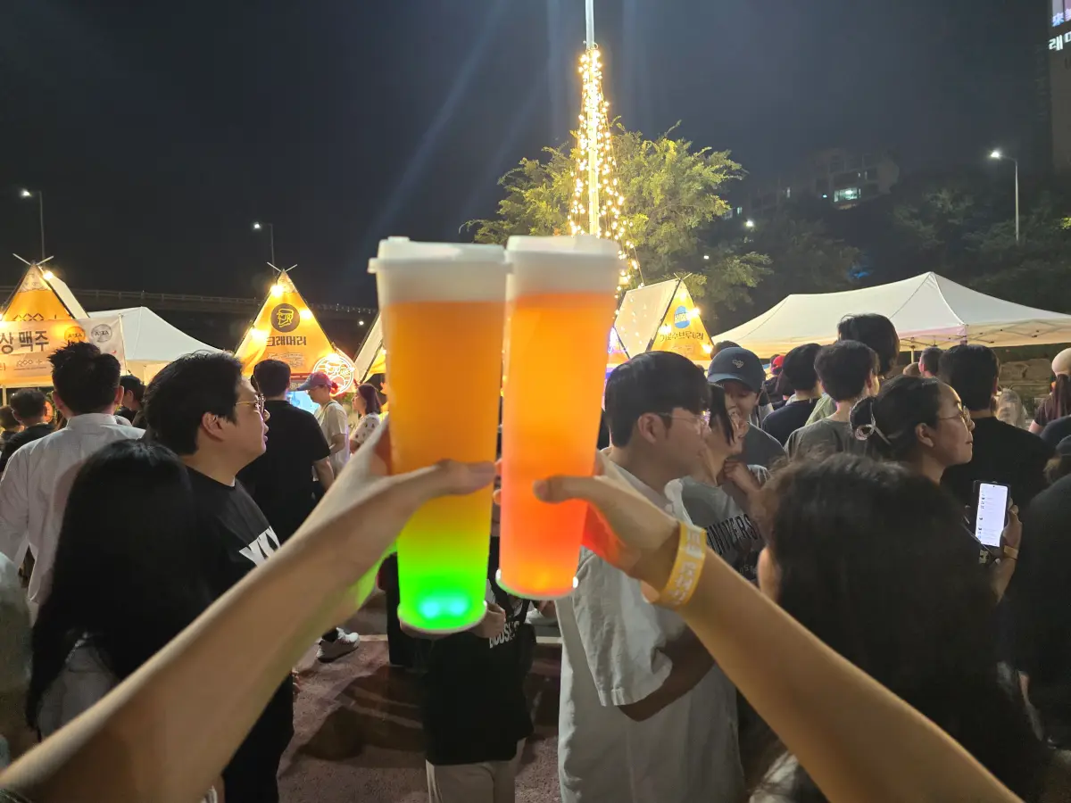 맥주를 나란히 들고 서있는 두사람의 손