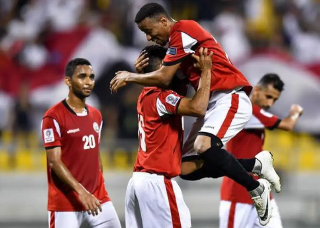 붉은 유니폼을 입고 서로 얼싸안는 싱가포르 선수들