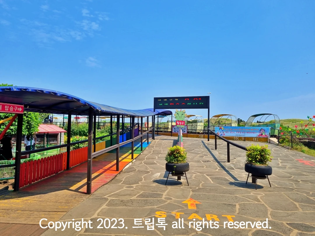 맑은 날씨에 무지개색으로 꾸며진 데크로 레일바이크 탑승구가 보인다.