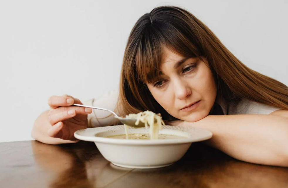 월경전증후군 증상 중 우울, 예민, 식욕 증가를 느끼고 있는 여성의 모습