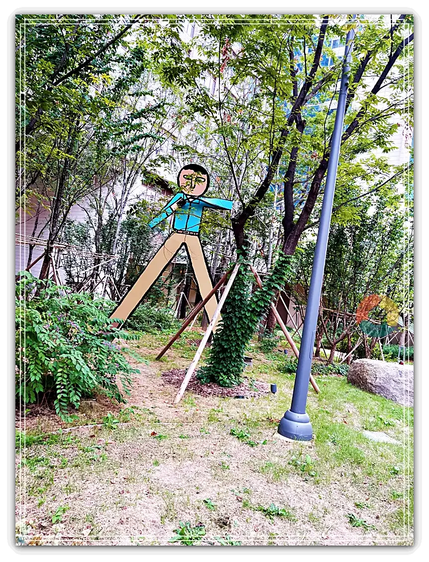 퍼블릭가산_전시1-서있는-사람-파란셔츠-갈색바지