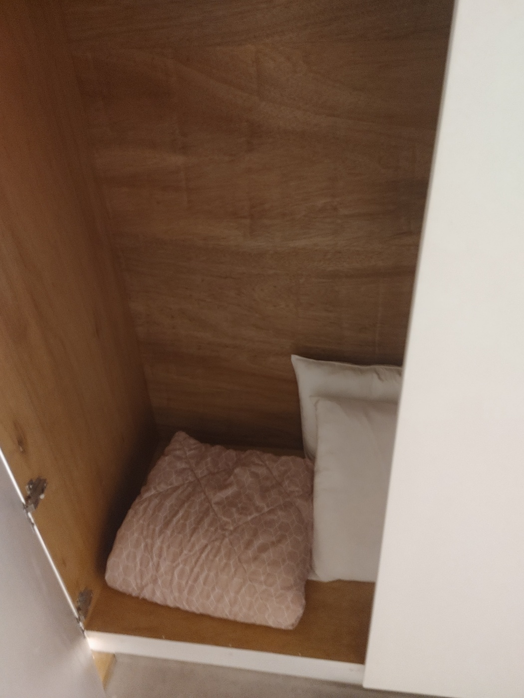 침대 옆에 수납장에 여분의 이불이 비치되어 있습니다.