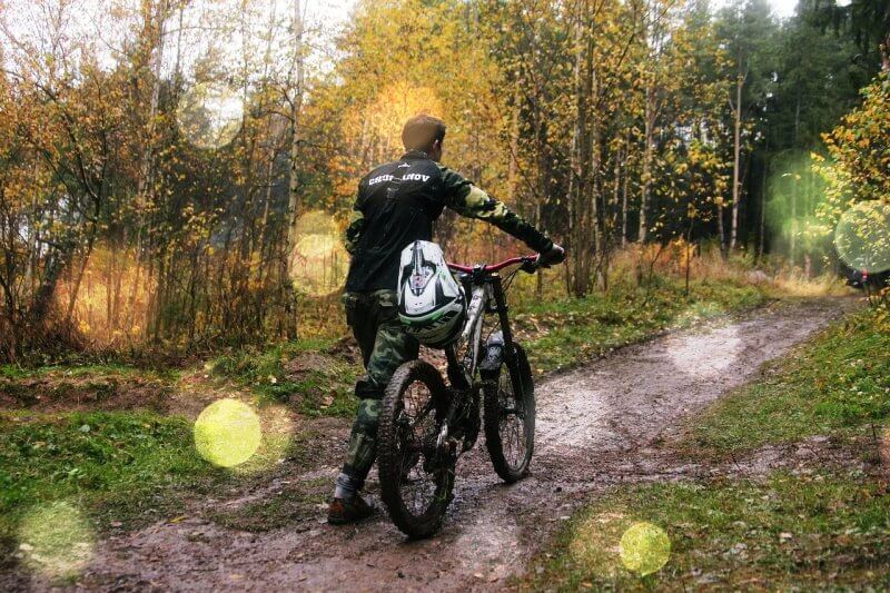 비오는-숲속에서-자전거-끌고가는-사람