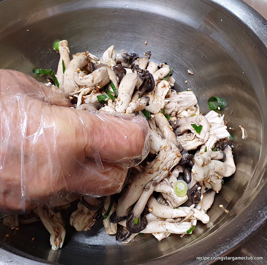양념을 넣은 느타리버섯을 손으로 버무리는 사진