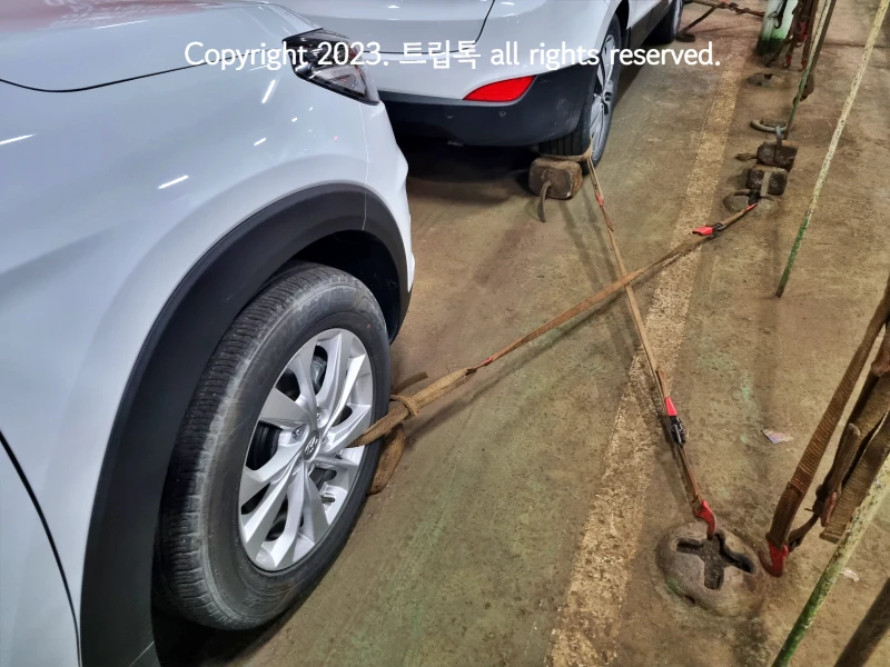 자동차 바퀴의 휠에 끈을 묶고 지지하는 물체를 괴어서 고정해둔 모습니다.