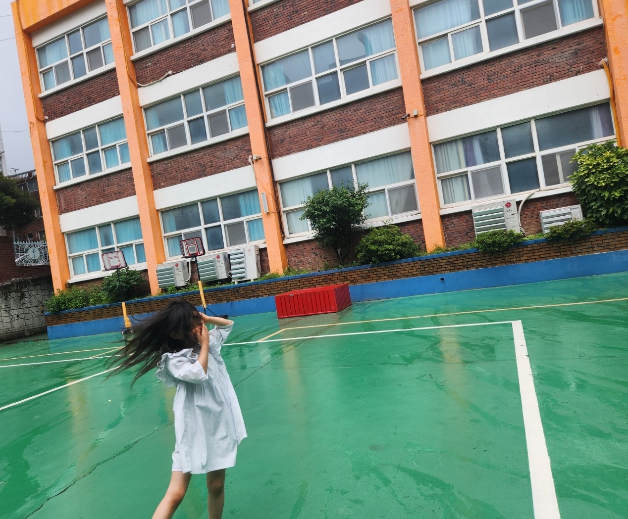 초등학교 운동장에 혼자 서 있는 일곱 살 아이의 모습. 영어유치원을 졸업하고 곧 일반 초등학교에 입학한다.