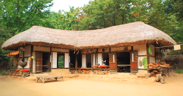 커다란 초가집 한 채가 있고, 흙마당은 얿다. 초가집 뒤에는 푸른 나무들이 많다.