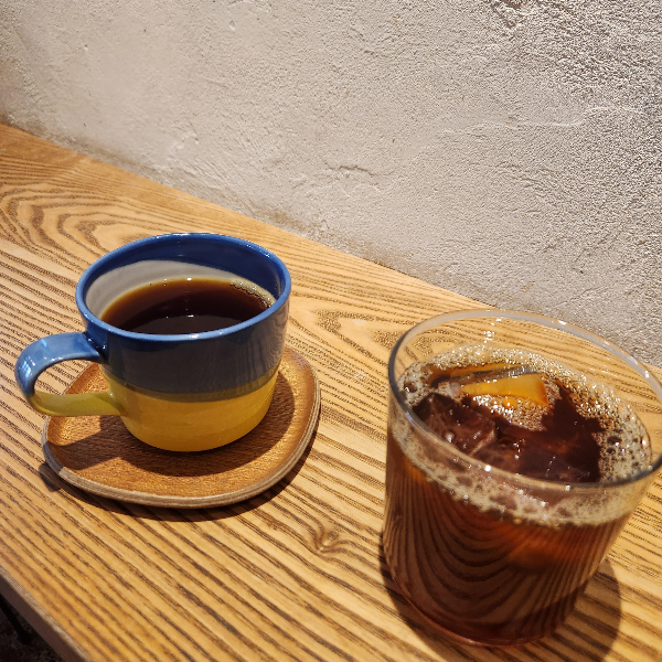 스탠드 테이블에 놓여진 커피잔. 게이샤 핫커피와 브라질 아이스 아메리카노