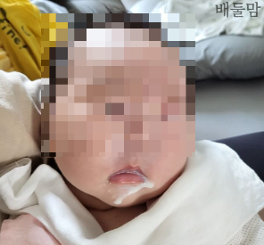 입 주변으로 분유가 흐르는 아기.