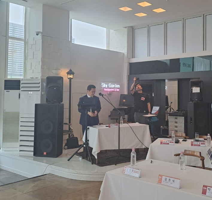 모맨틱스튜디오 사진촬영전문가 문민대표님께서 주간회의 모습을 회의장 정면에서 일어서서 촬영하는 모습입니다.