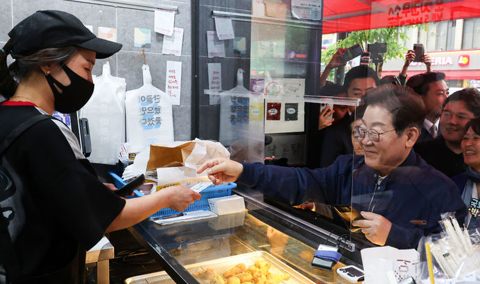 이재명 대통령이 더불어민주당 대선후보 시절 경기 포천시를 찾아 지역상품권으로 결제하고 있다