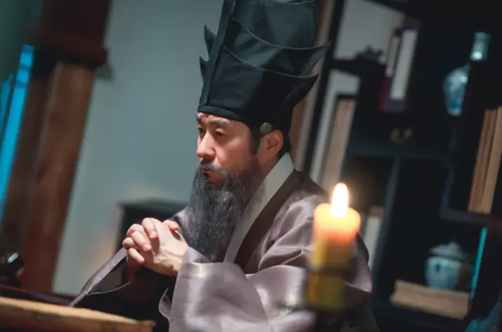 밤에 피는 꽃- 연보라색 한복을 입고 책상에 기대어 앉아 양반 두건을 쓰고 생각중인 석지성