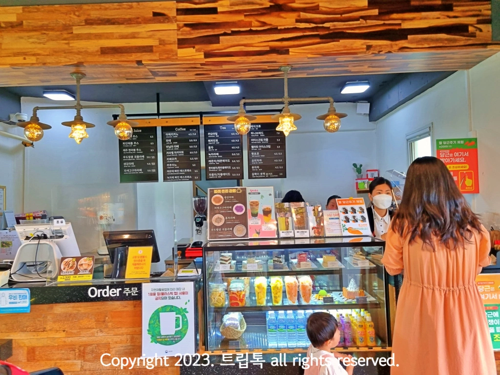 나무로 이루어진 내부에 음료와 메뉴판이 보인다.