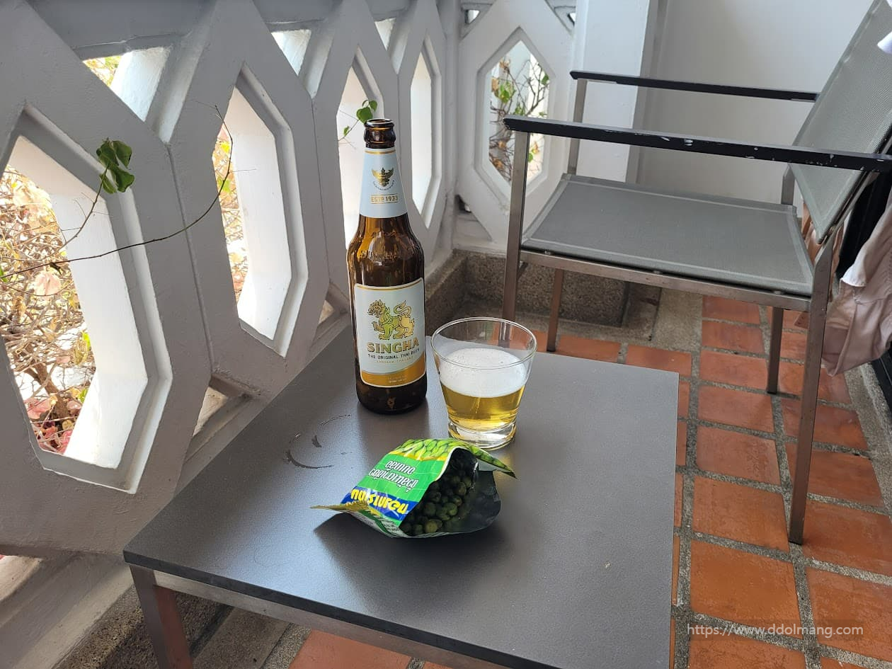 아난타라 리버사이드 리조트 객실 발코니에 완투콩 과자와 SINGHA 맥주가 놓여 있는 모습