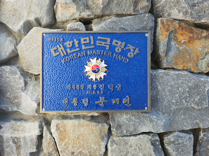 대한민국 명장 패찰이 돌로 된 벽에 걸려 있다