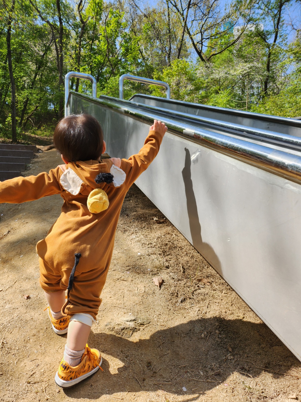 미끄럼틀을 잡고 걸어 올라가는 아이