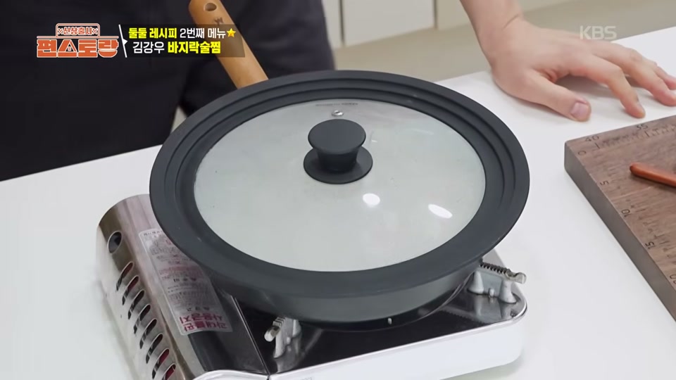 바지락과 소주를 넣고 뚜껑을 덮는 장면
