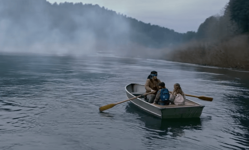 A mother, her young son and daughter blindfolded with a long cloth, ride down the river in a zonboat.