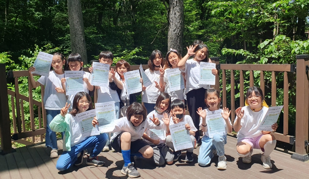 실천 서약서를 들고 의지는 다지는 학생들(대구반송초 3학년)