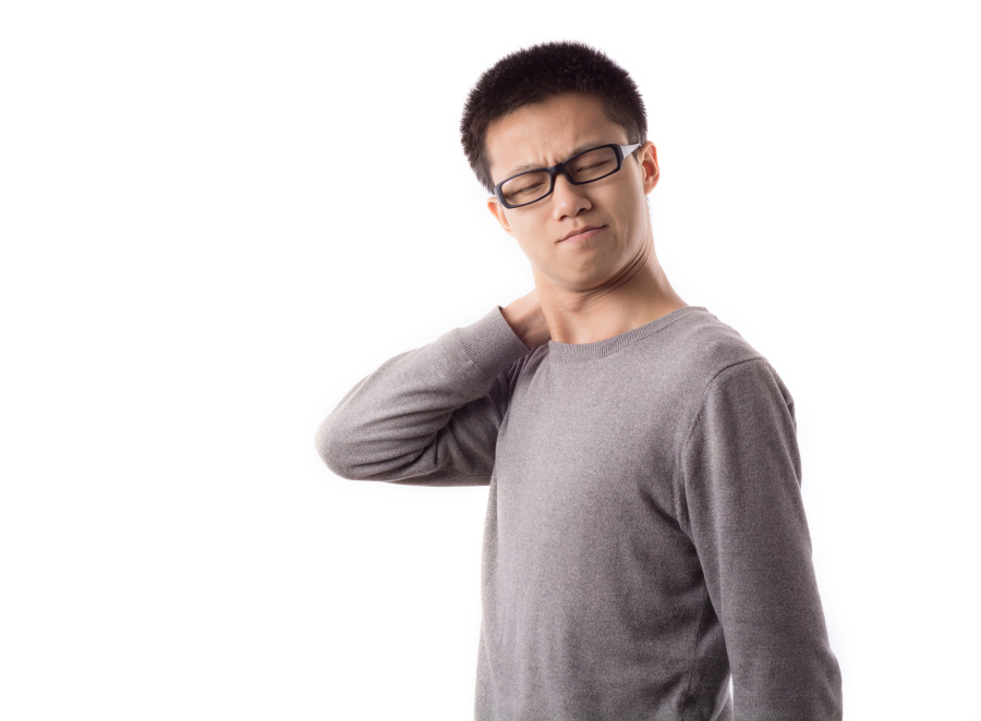 검은색 뿔테 안경을 쓴 젊은 아시아 남성이 목의 통증 때문에 고개를 왼쪽으로 돌리고, 오른쪽 손으로 목을 만지고 있는 것을 찍은 사진