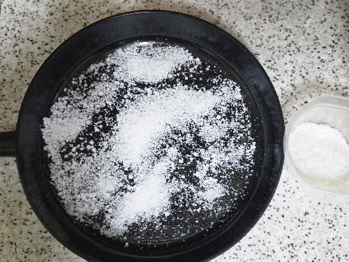 프라이팬의 기름때를 흡착하기 위해 굵은 소금을 넉넉히 뿌려둔 모습