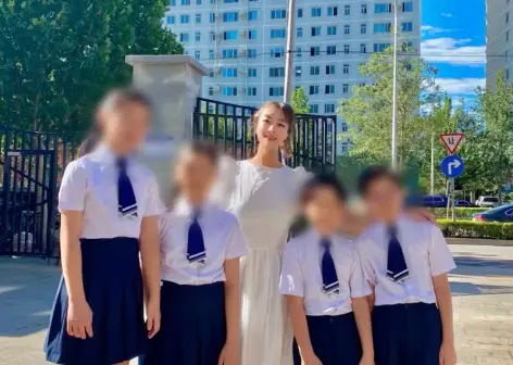 초등학교 교정 흰색 상의 교복을 입은 학생들과 어깨동무하고 사진찍은 순자