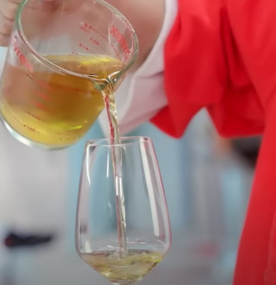 와인잔에 화이트 와인을 따르고 있다.
