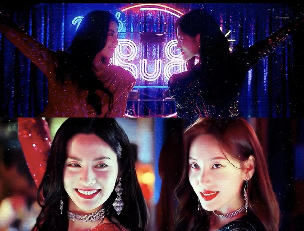 반짝이는 무대를 배경으로 반짝이는 짧은 원피스를 입고 춤을 추려는 동작을 하고 있는 드라마 마스크걸의 김모미와 김춘애