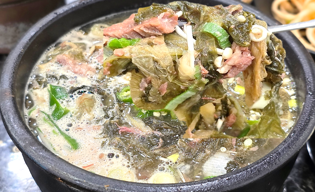 된장 베이스의 맑은 사골 국물과 건더기가 푸짐하게 들어간 수원 유치회관의 해장국 한 숟가락