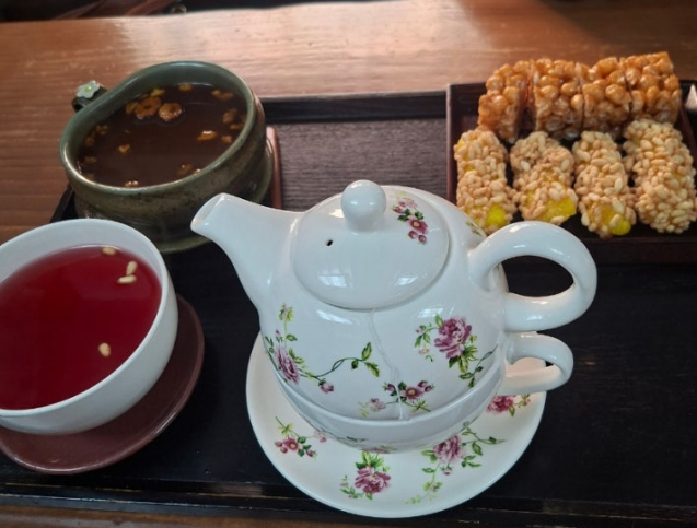 대추차, 오미자차, 그리고 예쁜 꽃무늬 찻주전자 세트와 전통 간식이 함께 놓인 정갈한 상차림