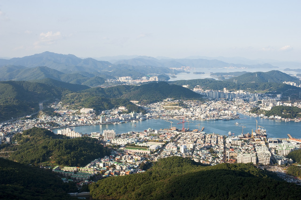 “미륵산 정상에서 바라본 통영 전경. 시내와 항구가 한눈에 내려다보이며, 도시 뒤로는 다도해의 섬들과 바다가 겹겹이 펼쳐진다.”