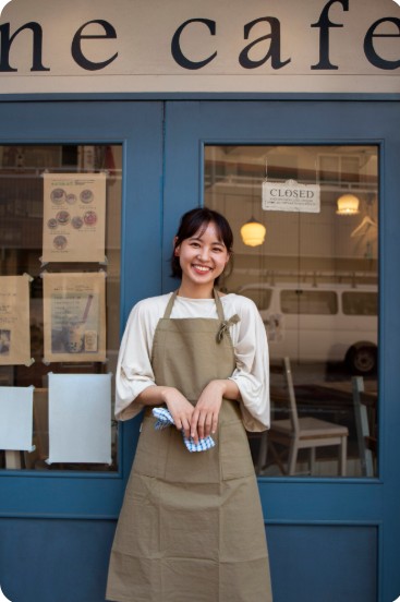 카페 앞에서 웃고 있는 사장님