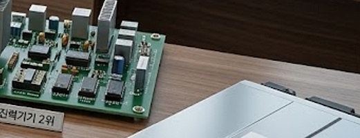 도시 전경이 보이는 사무실 책상 위에 반도체 웨이퍼&amp;#44; 전력 변압기&amp;#44; 바이오 현미경&amp;#44; 2차전지 배터리&amp;#44; 증권 분석 차트가 놓여 있는 실사 이미지