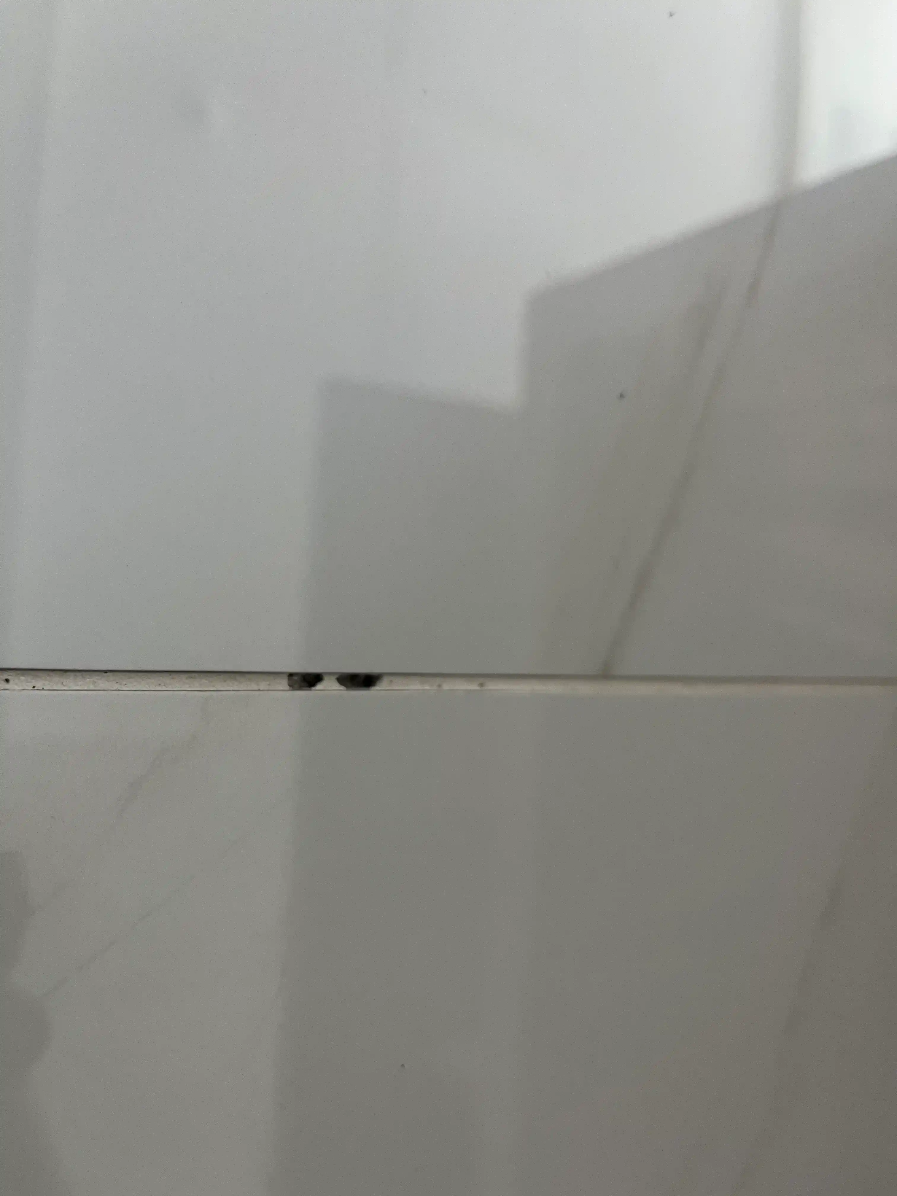 거실 폴리싱 타일 사이 채워진 백시멘트가 깨져있다.