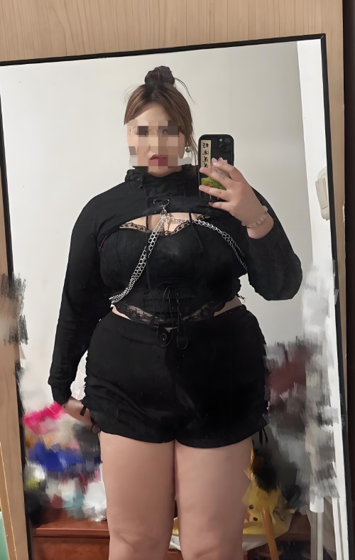 살이 많이찐 여성이 거울을 보며 핸드폰으로 본인을 찍고있음