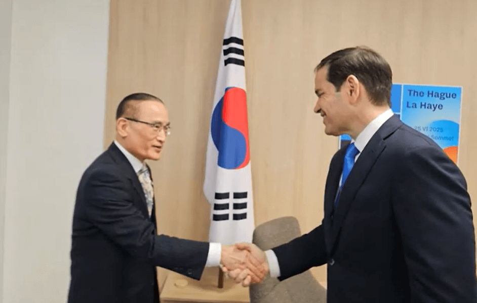 한국 국기 앞에서 두 인물이 악수하는 외교 회담 장면 이미지