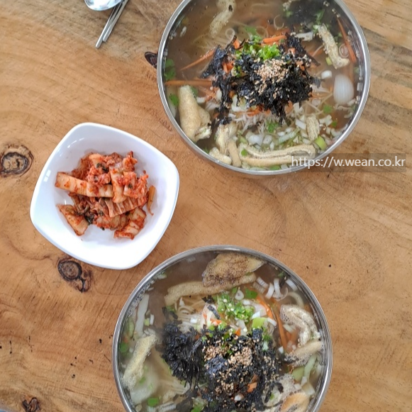 테이블에 국수와 김치가 있어요.