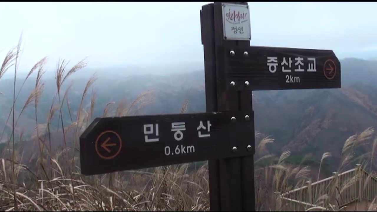하산 능선의 이정표 너머로 드러나는 산자락