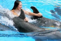 돌고래-두마리-지느러미를-잡고-밝게-웃으며-수영하는-여자