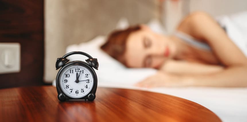알람 시계를 테이블 위에 올려 놓고 자고 있다