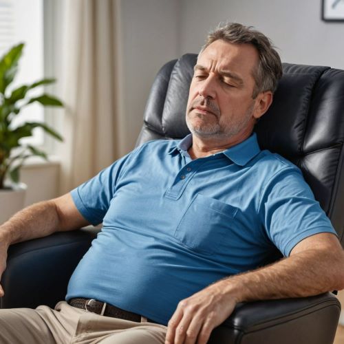 중년 남성이 만성피로증후군으로 의자에 앉아서 졸고 있다.