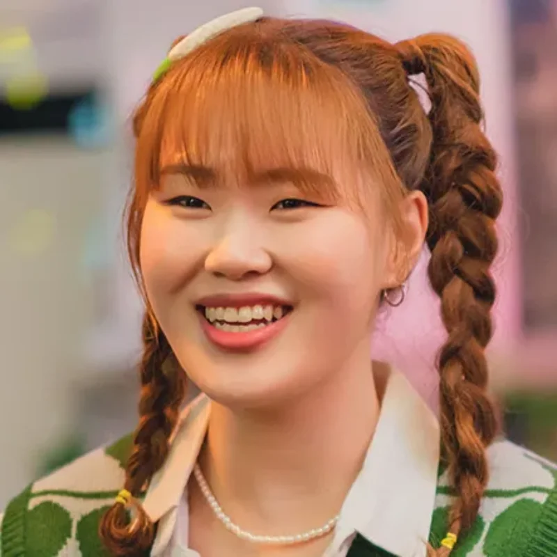 초록색 가디건을 입고 오렌지색 머리를 하고 있는 소용없어 거짓말의 황초록