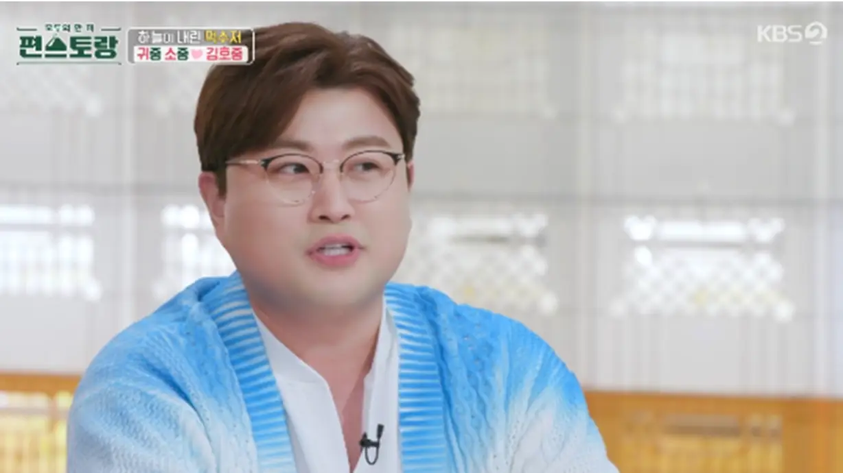 흰배경 파란색 니트를 입고 안경을 슨채 얘기하는 김호중